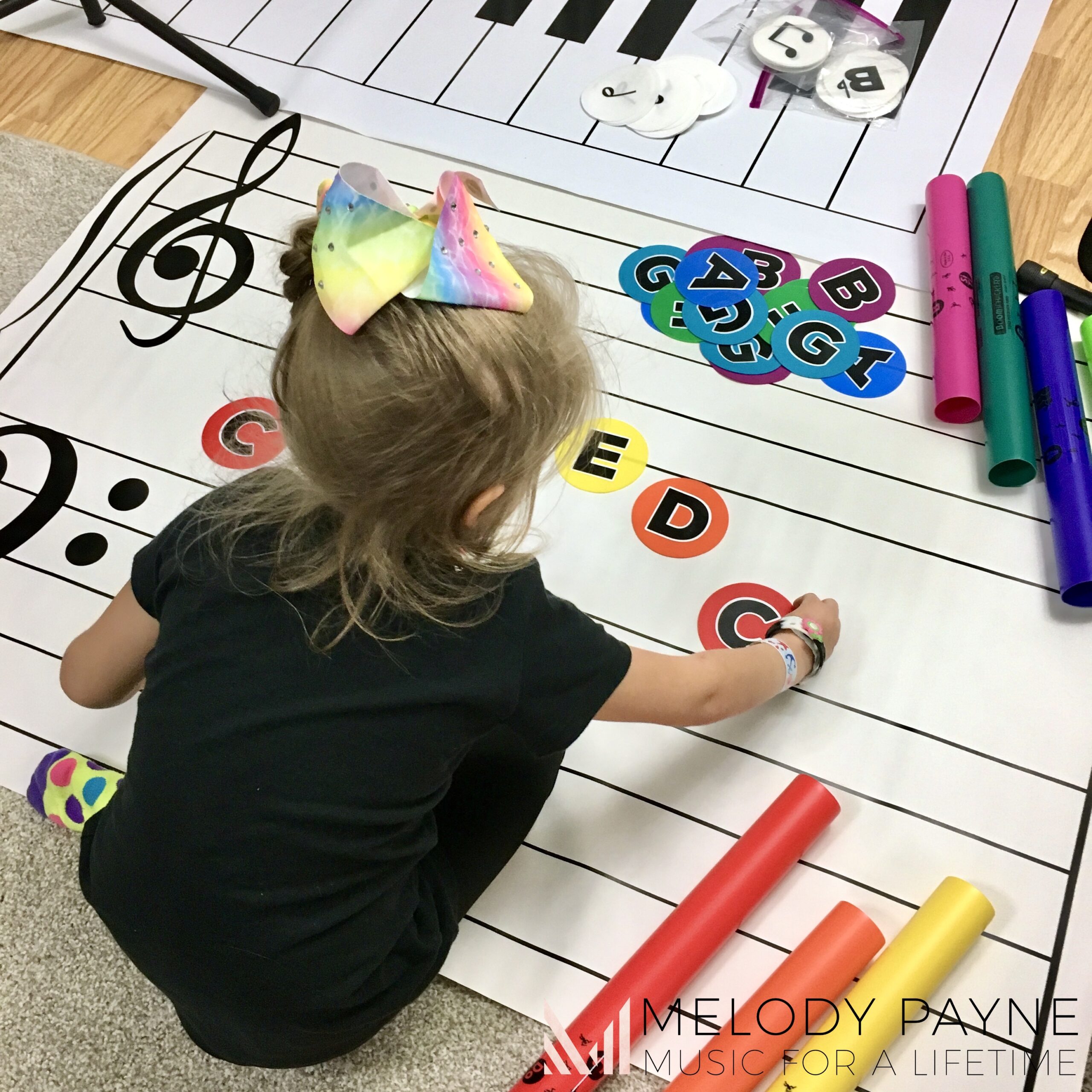 Young piano student composing with the giant floor staff