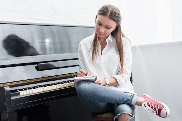How to Teach Piano Practice: Research-Based Strategies That Really Work 2 A piano student looks at her assignment sheet to see the practice strategies she needs to use